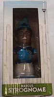 Front view of Marcus Strognome bobblehead in factory box showing clear front window and branded name.