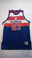 Full front view of the sleeveless Washington Bullets basketball jersey with red, white, and blue stripes and number 23