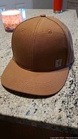 Front view of the brown Carhartt ball cap showing its solid color, curved brim, and front small logo patch.