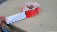 Roll of reflective tape showing red and white alternating sections and honeycomb pattern