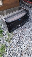 Front and side view of the folded Flexco RV camper step on gravel.