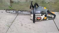 Right side view of Ryobi 40cc chainsaw with 18-inch Oregon Intenz bar showing handle, labels, and chain.