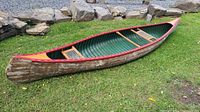 Side view of canoe showing overall shape, wood strip exterior and red gunwales