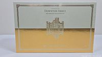 Front of the sealed Downton Abbey DVD box set showing gold and silver embossed design with the estate image and text.