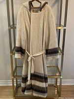 Full front view of the vintage long Icelandic wool coat in off-white with brown stripes and belt.