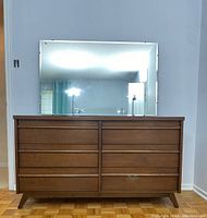 Straight-on view of dresser with mirror against light wall, showing overall design and finish