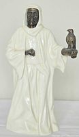 Front view of Minton The Sheikh figurine showing cream bone china robe with bronze head and hands, falcon on arm.