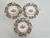 Overhead view of three Paragon Hydrangea teacups and saucers showing floral pattern and gold trim.