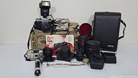 Overview of all contents on table including cameras, lenses, flash, bag and accessories