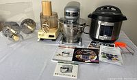 Full lot overview including food processor, stand mixer, Instant Pot and manuals