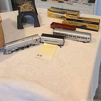 Tunnel, various train cars, and original American Flyer boxes on table