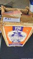Photo of the worn original box showing image and model number 236 of the Coleman vintage lamp.