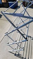 Close-up view of part of the white metal foldable drying rack showing the frame and cross bars.