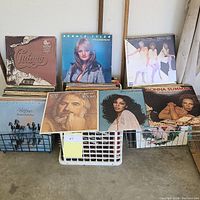 Overall view of some featured vinyl records propped on crates showing album covers from Chicago, Bonnie Tyler, Kenny Rogers, Donna Summer, and Pointer Sisters.