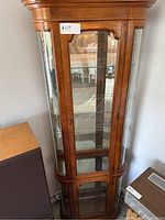 Front view of the solid oak display cabinet with glass panels and shelving inside.
