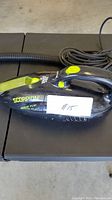 Photo of black Dirt Devil Scorpion handheld vacuum cleaner with attached hose and power cord, showing product label and condition.