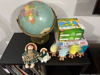 Replogle world paper globe on metal stand, Anne of Green Gables dolls, five vintage troll dolls with colorful hair, boxed Crayola word puzzles and Playskool game.