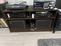 Front view of the media cabinet showing electronics and speakers inside compartments