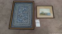 Both framed artworks side by side on carpet background with lot card.