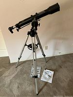Assembled telescope on tripod with manuals on floor