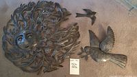 Photo showing all three metal wall decor pieces: a large sun with face and two birds.
