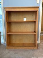 Front view of pine bookshelf showing three shelf levels including two adjustable ones.