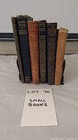 Front view of six small antique books showing titles and spines, arranged side by side
