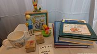 Overview of Winnie-The-Pooh figurines, stamps, mug, and books.