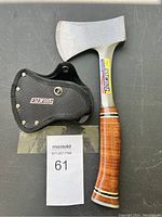 Full view of Estwing camping hatchet and black fabric sheath with snap closure.