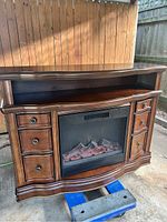 Full front view showing the wooden electric fireplace cabinet with drawers and artificial ember fireplace insert.