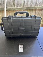 Closed black Apache 5800 rolling protective case on outdoor table with sturdy handle visible.