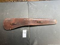 Full view of the long brown leather holster showing shape and belt loops.