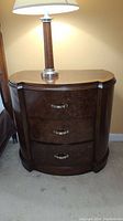 Front view of Pulaski Furniture Co. nightstand showing the three curved front drawers with metal handles and wood veneer finish.