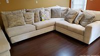 Front view of full off-white sectional sofa with throw pillows