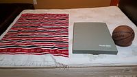Photo shows the scarf, Stairslide cushion, and Wilson basketball laid out on a bed for clear view of all items.