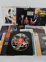 Photo showing a collection of 20 vinyl album covers including Joe Jackson, Cream, Tom Petty, Pete Townshend, John Fogerty and more arranged in a fanned display.