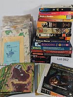 Stack of boxed games with loose map boards and bagged components