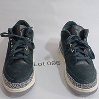 Front view of pair of black Nike Air Jordan 3 Retro sneakers with elephant print accents and white midsoles.