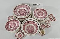 Full overview of the Mason's Vista red stoneware set including multiple stacks of plates, bowls, covered dishes, salt and pepper shakers, and toothpick holder arranged on the floor.