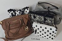 Five handbags arranged together showing the collection included in the lot