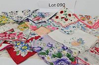 Top view showing overlapping vintage handkerchiefs with various floral prints and scalloped edges.