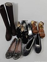 Photo showing all 6 pairs of shoes including tall boots, heeled sandals, and flats in various styles and colors.