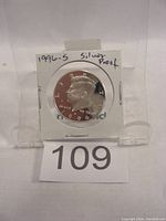 Front view of 1996-S Kennedy silver proof half dollar coin in cardboard holder labeled '1996-S Silver Proof'. Coin shows clear proof strike features with mirror-like background and frosted raised details.