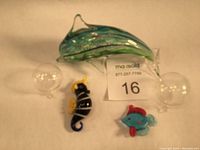 Photo of the three glass fish figurines: large hand-blown glass dolphin with specks of metallic colors and two smaller floating fish figurines: seahorse and sunfish.