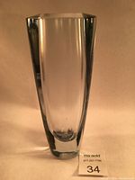 Front view of the clear glass vase showing its elongated, smooth body and thick base.