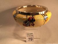 Yellow pearl lustre vase with visible multi-colored decal Oriental lanterns and removable polished silver rim.