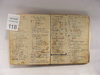 View of open recipe book pages showing handwritten dessert recipes in cursive script, some with stains and tears.