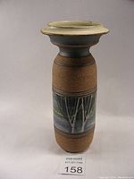 Full view of ceramic vase showing shape, colors and design