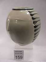 Side view showing subtle raised facial features: eyebrow and nose on the porcelain vase with celadon glaze.
