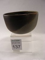 Front left angle view of ergonomic stoneware bowl showing matte dark exterior glaze and rounded form
